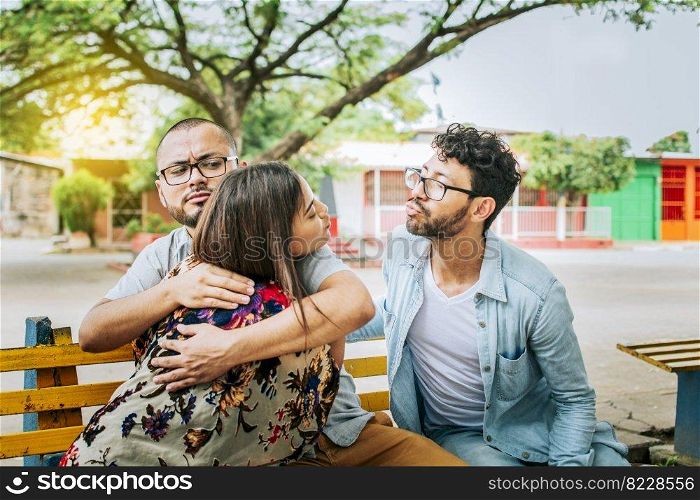 Unfaithful girlfriend hugging her boyfriend in a park secretly kissing another man. Couple infidelity concept, Unfaithful woman sitting hugging her boyfriend and secretly kissing another man.
