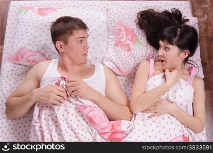 Unfamiliar young girl and the guy awake in bed