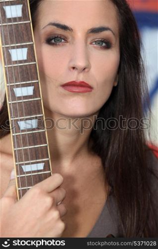 Unfriendly woman posing with her guitar