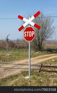 unguarded railway crossing with St. Andrews cross in early spring