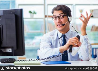 Unhappy angry call center worker frustrated with workload. The unhappy angry call center worker frustrated with workload