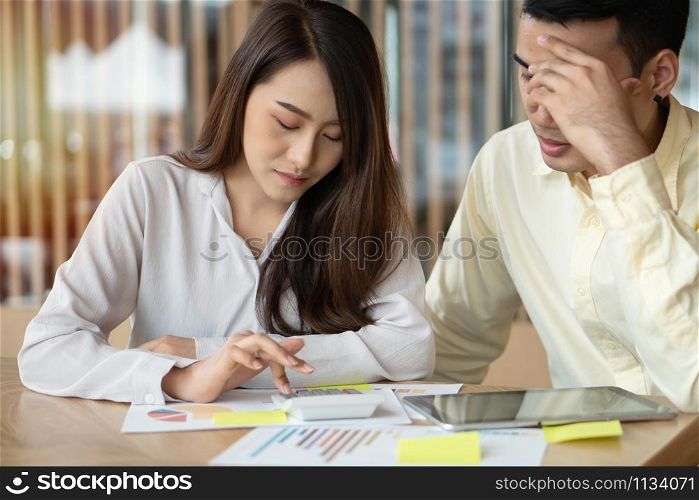 Unhappy Asian couples are calculating income And expenses To cut unnecessary expenses. Concepts for investment planning and financial planning for the family, Problems with money in the family