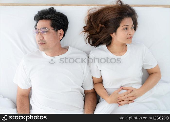 Unhappy Asian senior couple in bedroom. Retirement and bad relationship elderly concept.
