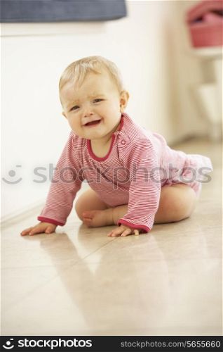 Unhappy Baby Girl Sitting On Floor Crying