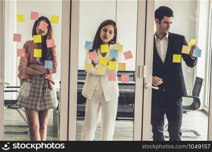 Unhappy business people feel disappointed while looking at sticky note on the windows in the office. Bankruptcy and failure concept.