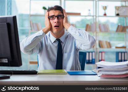 Unhappy businessman sitting at desk in office