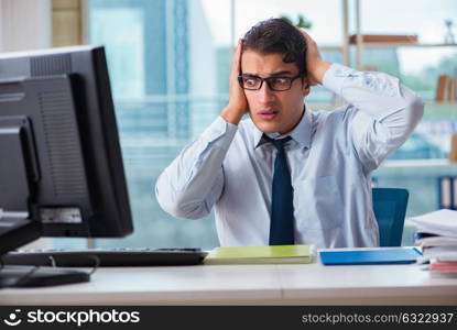 Unhappy businessman sitting at desk in office