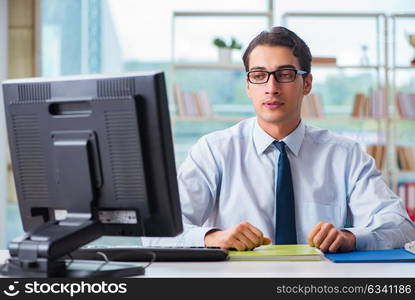 Unhappy businessman sitting at desk in office