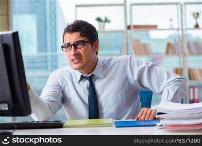 Unhappy businessman sitting at desk in office