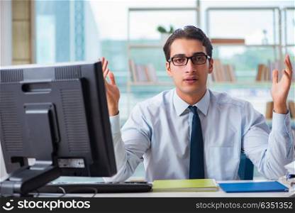 Unhappy businessman sitting at desk in office. The unhappy businessman sitting at desk in office