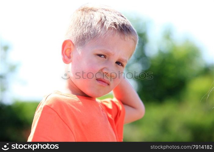 unhappy child expression. Sad little boy outdoor