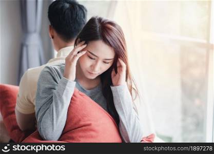 Unhappy Couple sitting behind each other on the couch and avoid talking or looking at each other, Cause of relationship problems and having misunderstanding or disagreement. Family problems concept