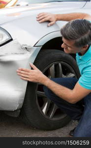 Unhappy Driver Inspecting Damage After Car Accident