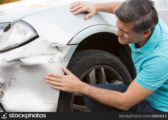 Unhappy Driver Inspecting Damage After Car Accident