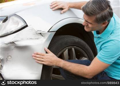 Unhappy Driver Inspecting Damage After Car Accident