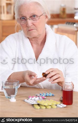 Unhappy elderly lady taking her medication