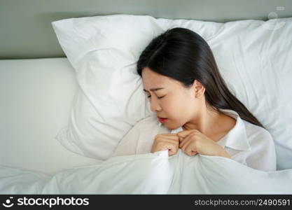 Unhappy exhausted woman closed eyes lying in bed cause of Headache, sore throat and tired, Concept of recuperation from illness, feeling unwell and healthcare.