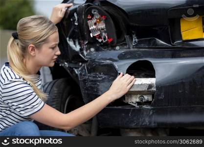 Unhappy Female Driver Inspecting Damaged Car After Accident