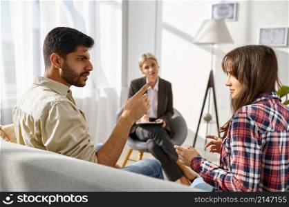 Unhappy frustrated couple arguing discussing relationship problems at psychologists office. Unhappy couple arguing disagreement at psychologists office