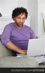 unhappy man doing computer on a couch