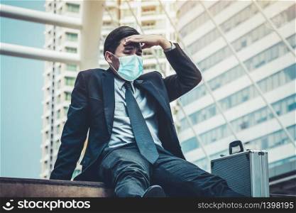Unhappy sad business man with face mask protect from Coronavirus or Covid-19. Concept of unemployment problem caused by Coronavirus Covid-19.