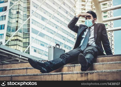 Unhappy sad business man with face mask protect from Coronavirus or Covid-19. Concept of unemployment problem caused by Coronavirus Covid-19.