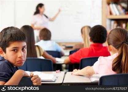 Unhappy schoolboy in class