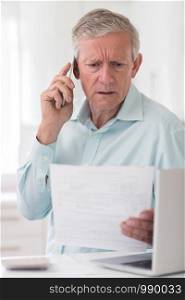 Unhappy Senior Man On Phone Querying Bill