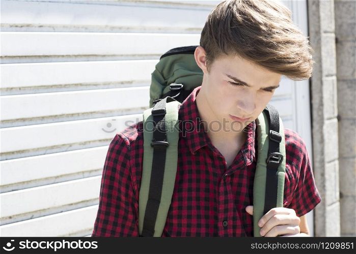 Unhappy Teenage Boy On The Streets With Rucksack