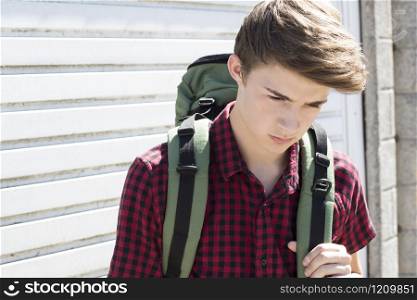 Unhappy Teenage Boy On The Streets With Rucksack