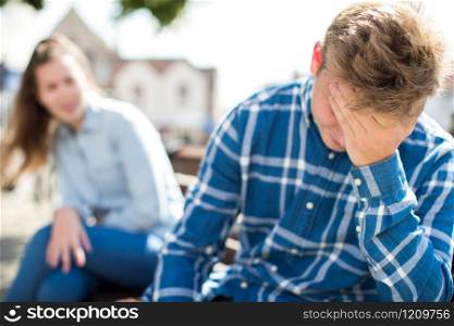 Unhappy Teenage Couple Having Argument In Urban Setting