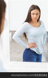 Unhappy Teenage Girl Looking At Reflection In Mirror