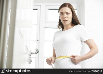 Unhappy Teenage Girl Measuring Waist