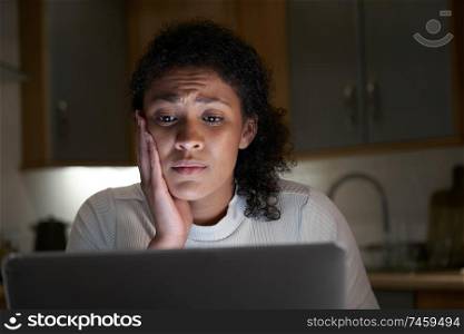 Unhappy Woman At Home With Computer Being Bullied Online On Social Media