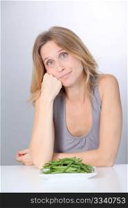 Unhappy woman in front of green beans