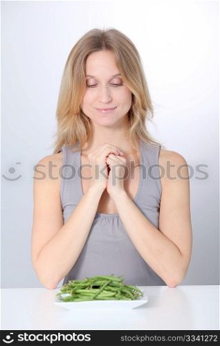 Unhappy woman in front of green beans