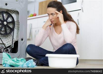unhappy woman looking at clothes in utility room