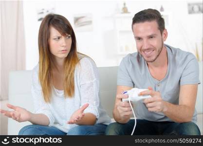 unhappy woman playing video games with partner