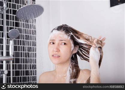 unhappy woman washing head with shampoo and the shower