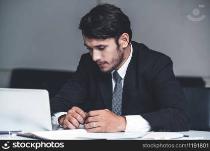 Unhappy young man, businessman feels stress at the office because of economic crisis and awful company loss. Business failure concept.