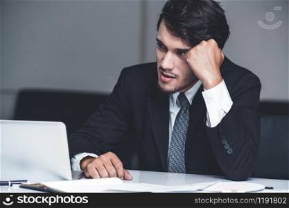 Unhappy young man, businessman feels stress at the office because of economic crisis and awful company loss. Business failure concept.