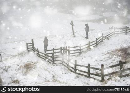 Unidentified hikers in Winter landscape image in Peak District England with public playing in snow in heavy snow storm