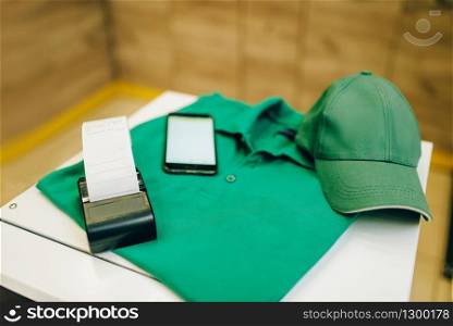 Uniform and cash register on the table, nobody. Repair service concept, electrician or plumber occupation, home repairing business