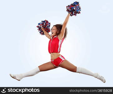 Uniformed cheerleader jumps high in the air isolated on white.