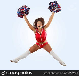 Uniformed cheerleader jumps high in the air isolated on white.