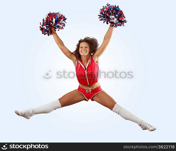 Uniformed cheerleader jumps high in the air isolated on white.