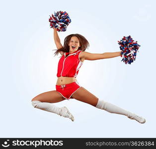 Uniformed cheerleader jumps high in the air isolated on white.