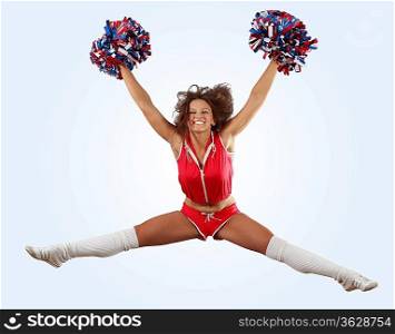 Uniformed cheerleader jumps high in the air isolated on white.