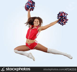 Uniformed cheerleader jumps high in the air isolated on white.