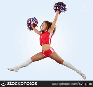 Uniformed cheerleader jumps high in the air isolated on white.